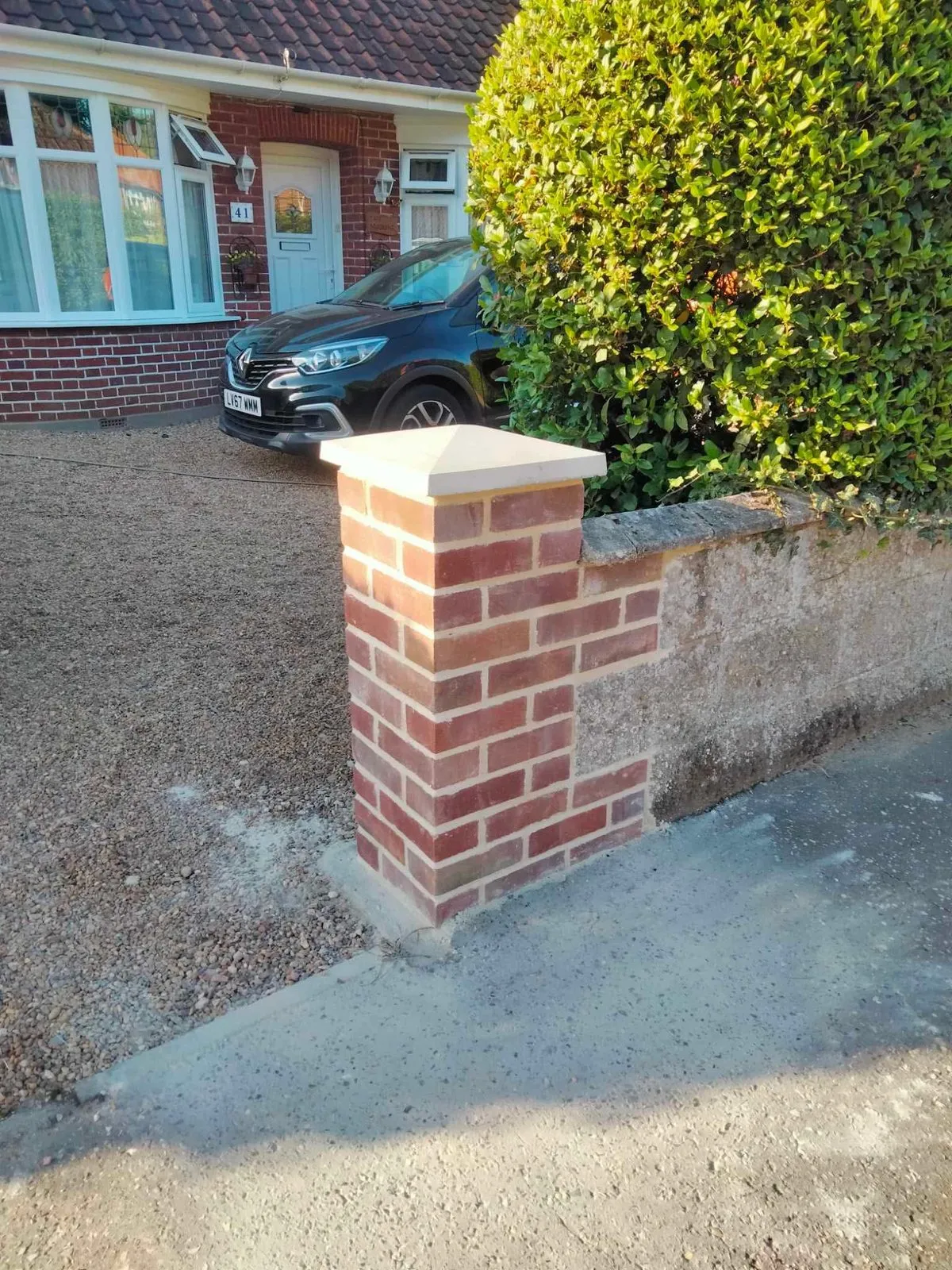 A newly built timber fence beside raked bare soil, with trees beyond