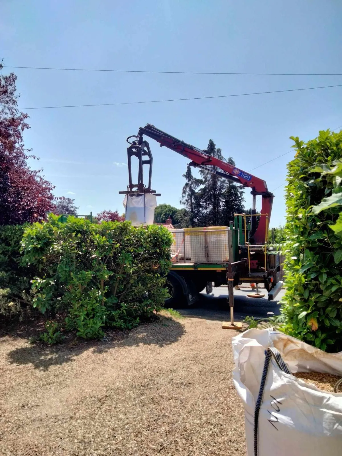 A garden retaining wall mid-rebuild, with upright posts and a yellow string line